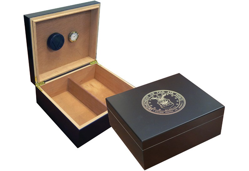 Two humidors in black finish one is open showing a humidifier and hygrometer the other one is closed with the air force emblem engraved on top