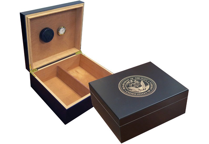 Two humidors in black finish one is open showing a humidifier and hygrometer the other one is closed with the US Navy emblem engraved on top