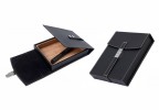 Two small black leather humidors with a black leather strap and a magnetic latch, one is open showing the interior the other one is closed.