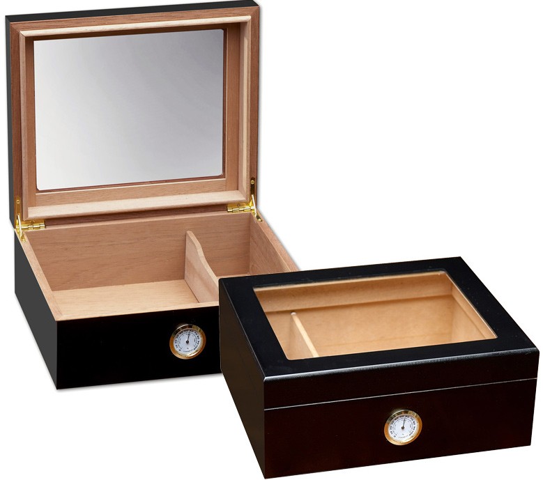 Two small and elegant glass humidors in black with see through glass on top and an external hygrometer, one humidor is closed and the other one is open