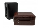 Two travel humidors in black leather one is open showing four cigars, a guillotine cigar cutter and a flip-top lighter the other is closed