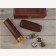 A closed humidor with brown alligator pattern next to a leather cigar humi-tube,two humidifiers, a hygrometer, a leather case and a guillotine cutter